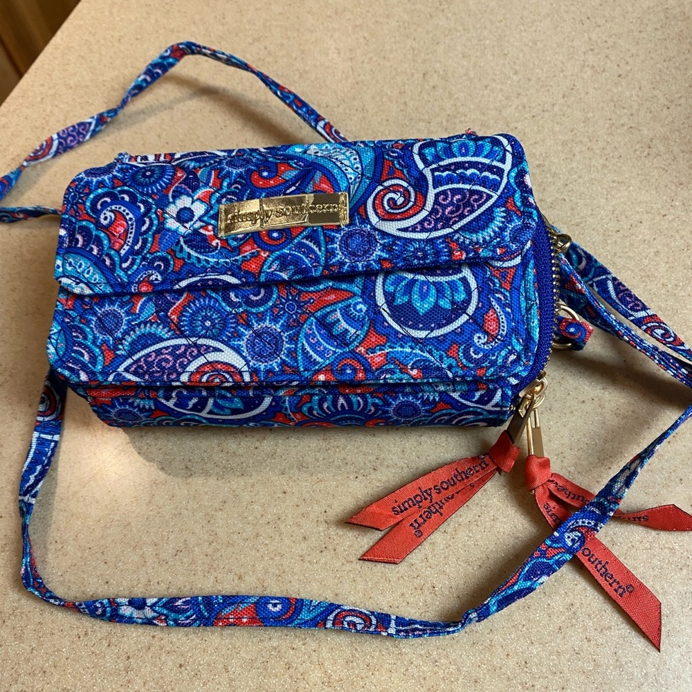 Small purse with shoulder strap and wrist strap.